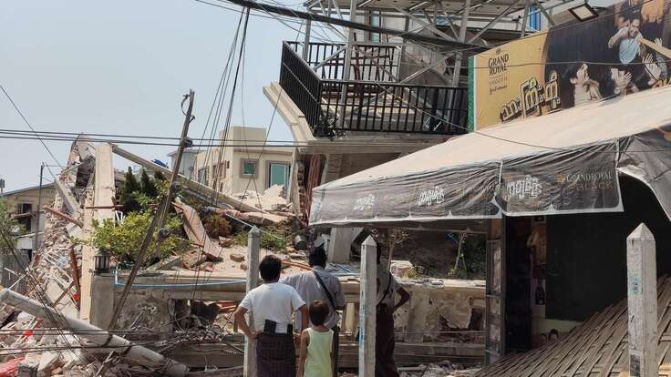 미얀마 지진 현장에서 사람들이 무너져내린 잔해를 바라보고 있습니다